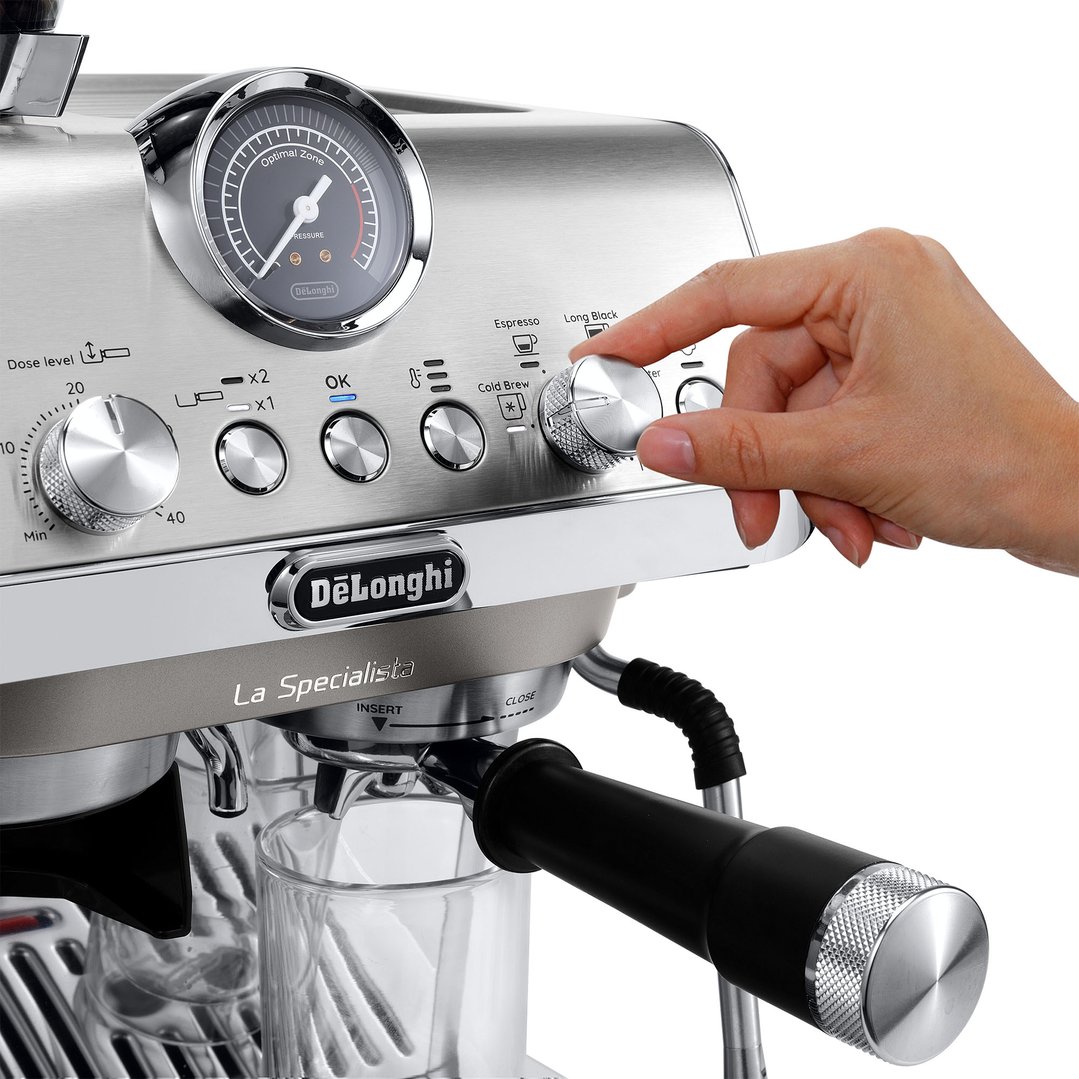 Hand adjusting settings on a DeLonghi La Specialista Arte Evo coffee machine