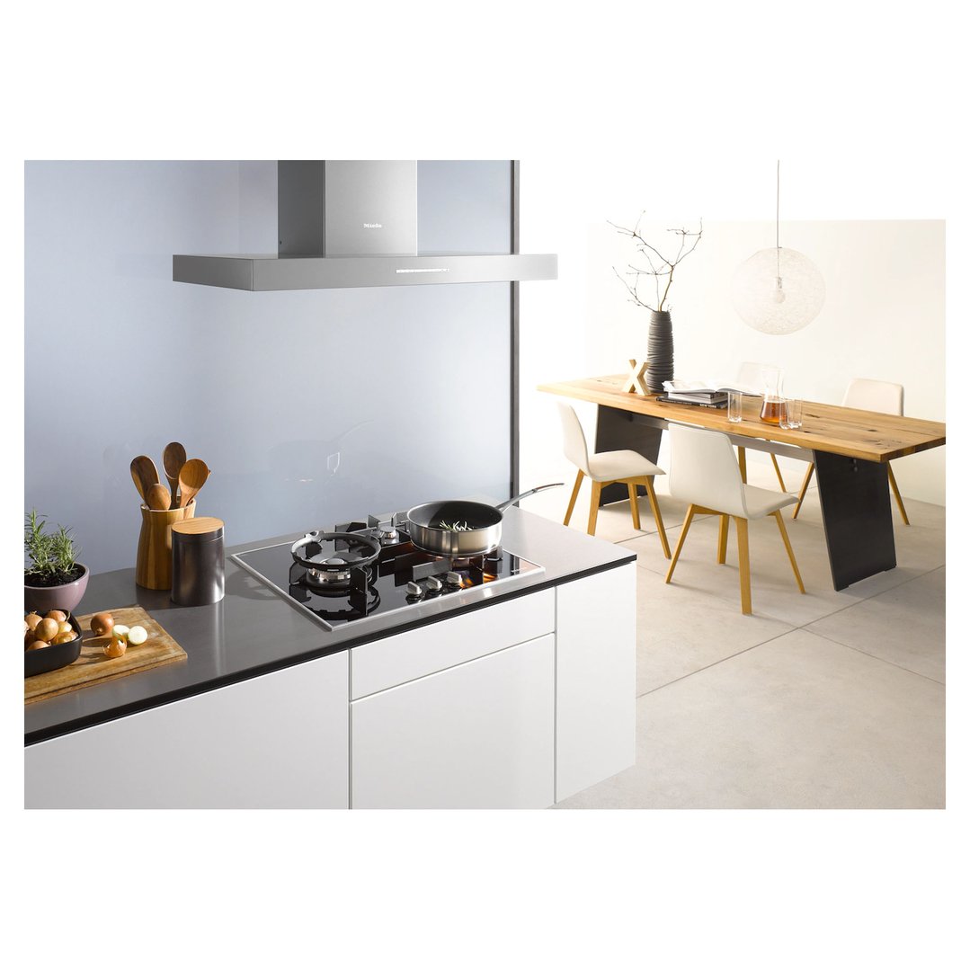 Cooktop with a pan on a kitchen island in an open-plan kitchen and dining area