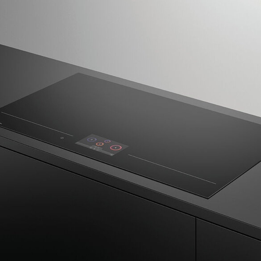 Black induction cooktop with a digital display built into a dark kitchen counter