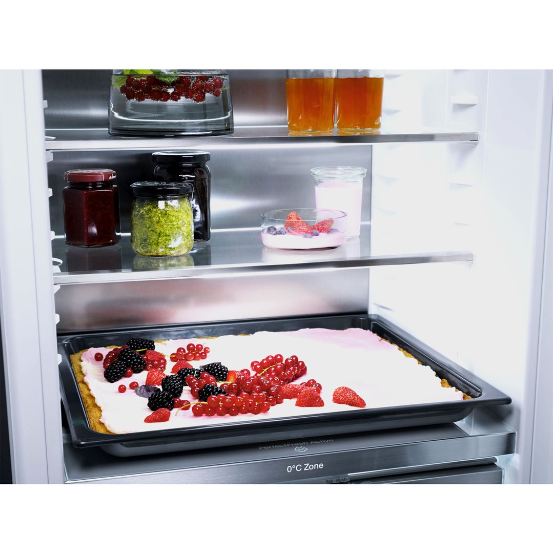 A fully integrated bottom mount fridge freezer with food items on shelves