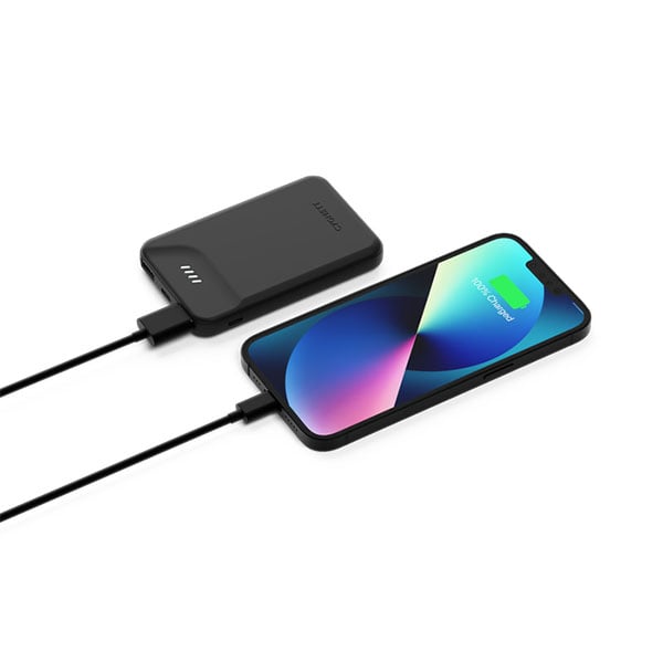 Black power bank charging a smartphone with a cable on a white background