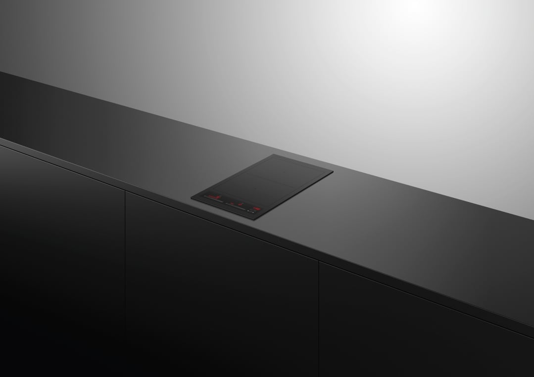 Black induction cooktop built into a dark kitchen countertop