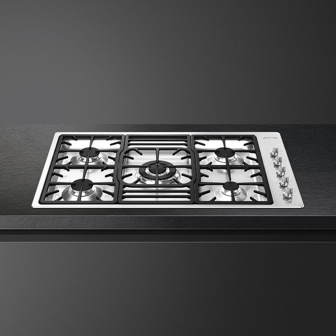 Stainless steel 90cm gas cooktop with five burners built into a dark countertop