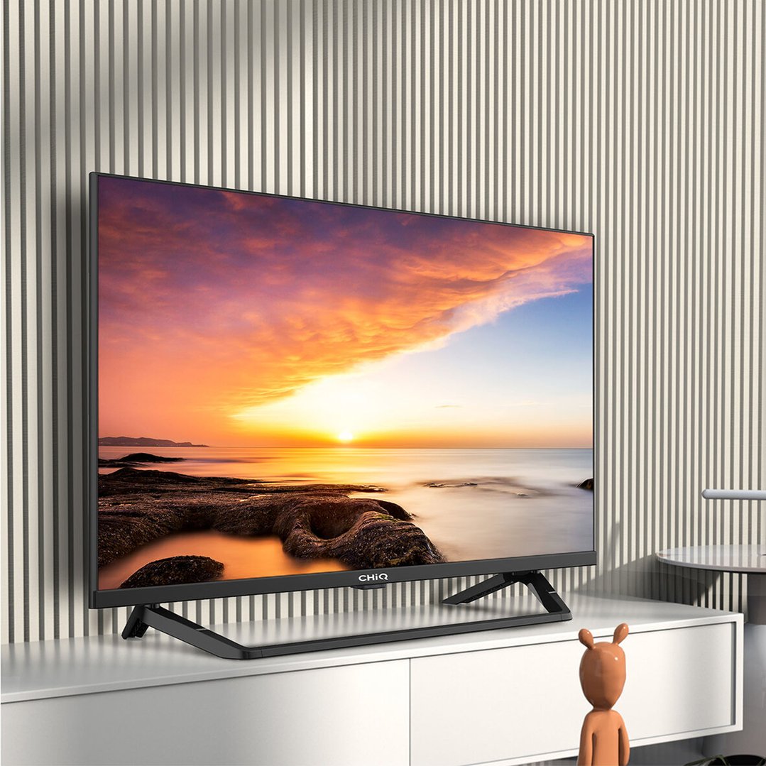 CHIQ 32 inch TV displaying a sunset scene, on a white cabinet