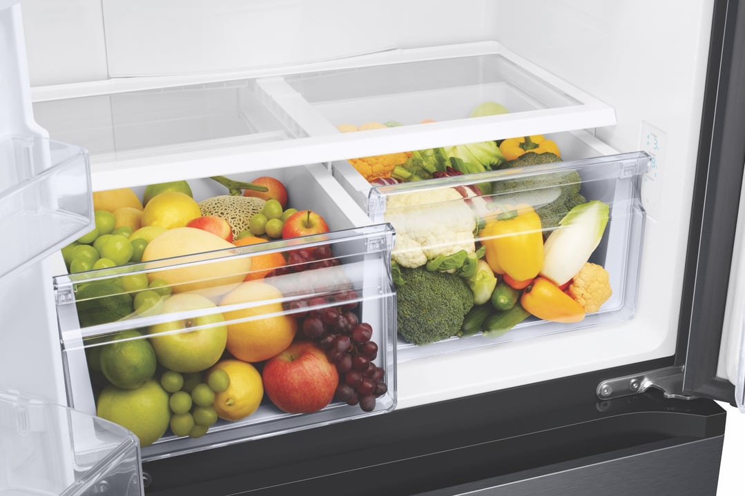 Open French door refrigerator with fruit and vegetables in clear crisper drawers