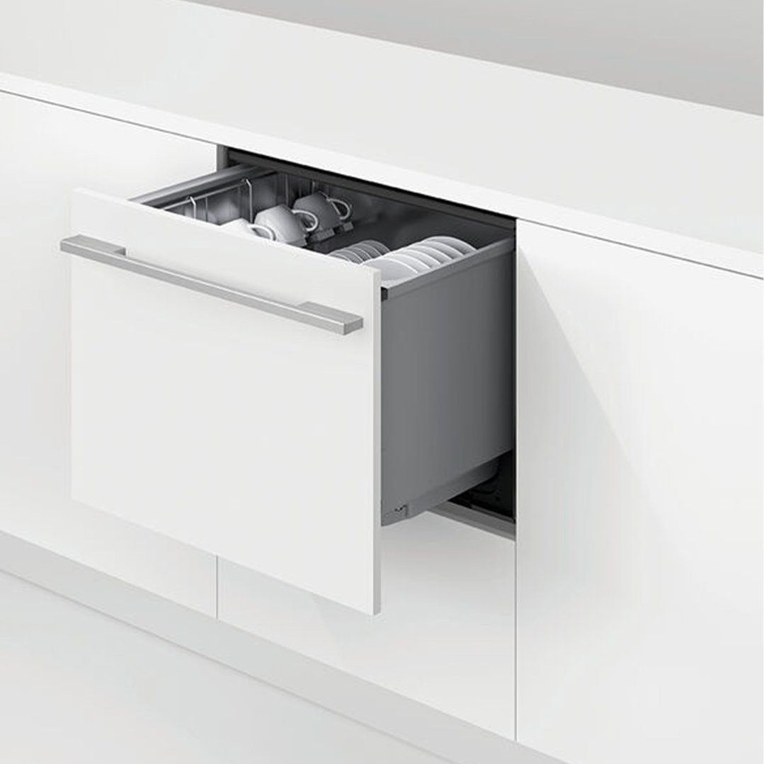 Open DishDrawer dishwasher with dishes and cups inside, integrated into white cabinetry