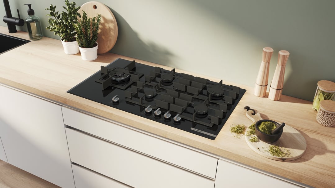 Black Bosch gas cooktop in a modern kitchen with wooden countertop