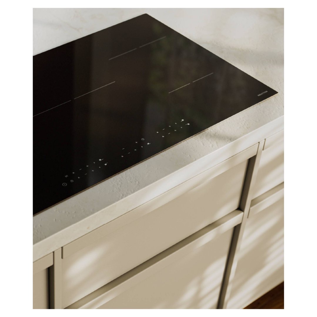 Black induction cooktop built into a light-colored kitchen countertop