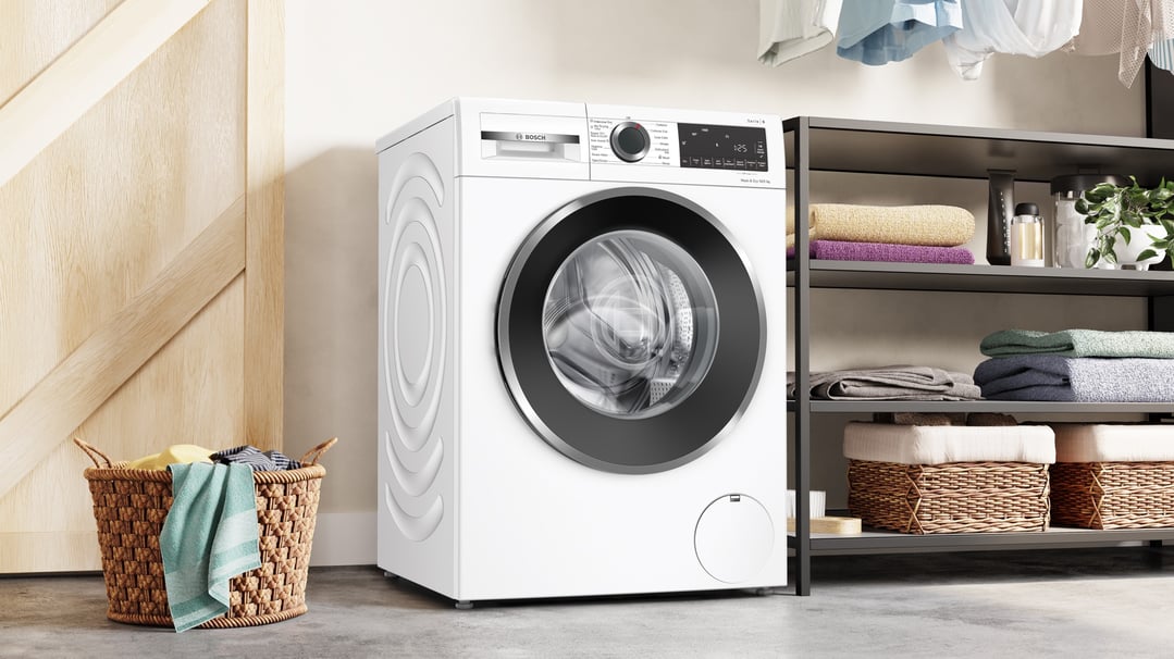 Bosch 10/5kg washer dryer combo in a laundry room with a laundry basket