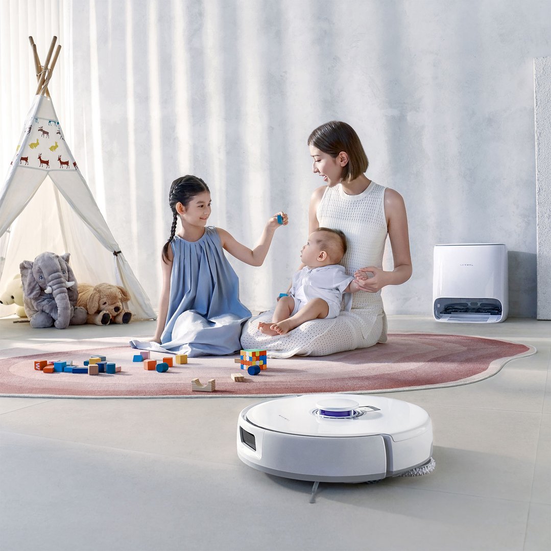 A family with a robotic vacuum and mop in a living room
