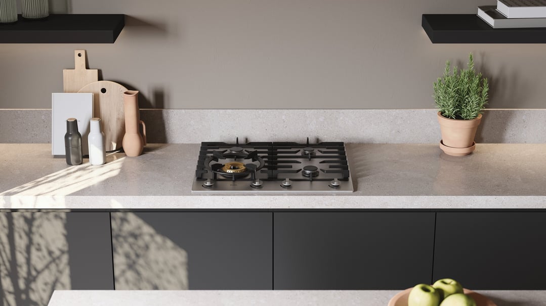 Stainless steel gas cooktop in a modern kitchen with decorative items