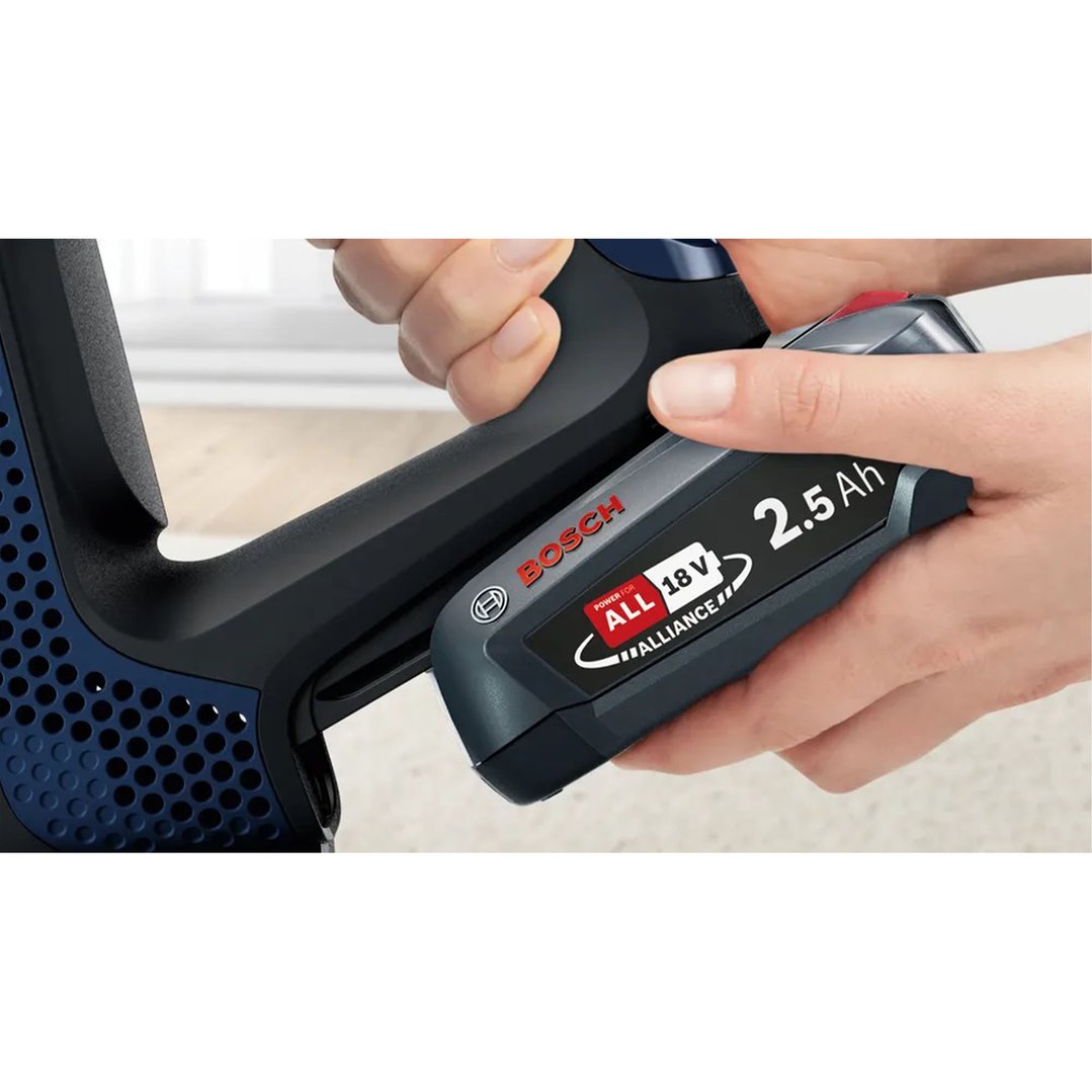 Hands inserting a Bosch 2.5 Ah 18V battery into a rechargeable vacuum cleaner