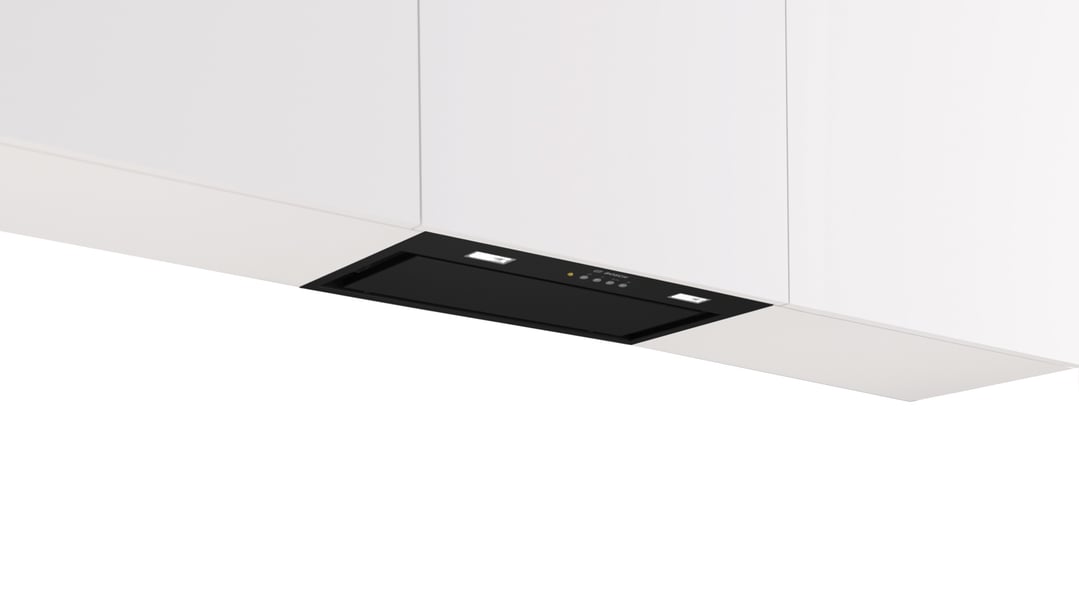 Black integrated rangehood installed under white kitchen cabinetry