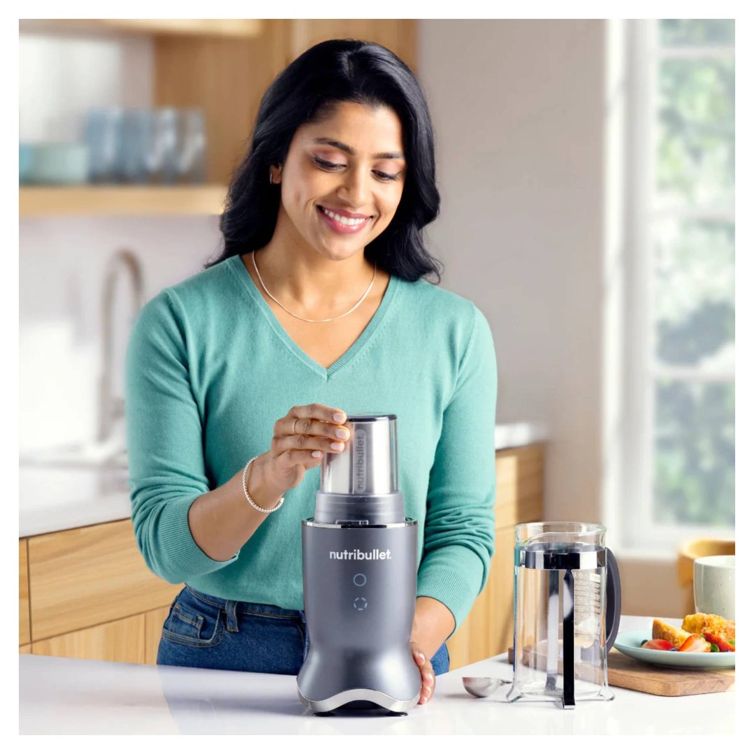 Woman placing the cup onto a NUTRiBULLET blender in a kitchen setting