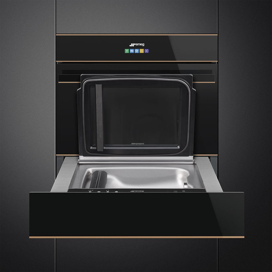 Black built-in sous-vide and vacuum drawer with open door in a dark kitchen