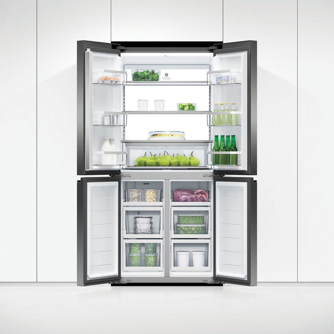 Open quad door refrigerator freezer filled with food in a white kitchen