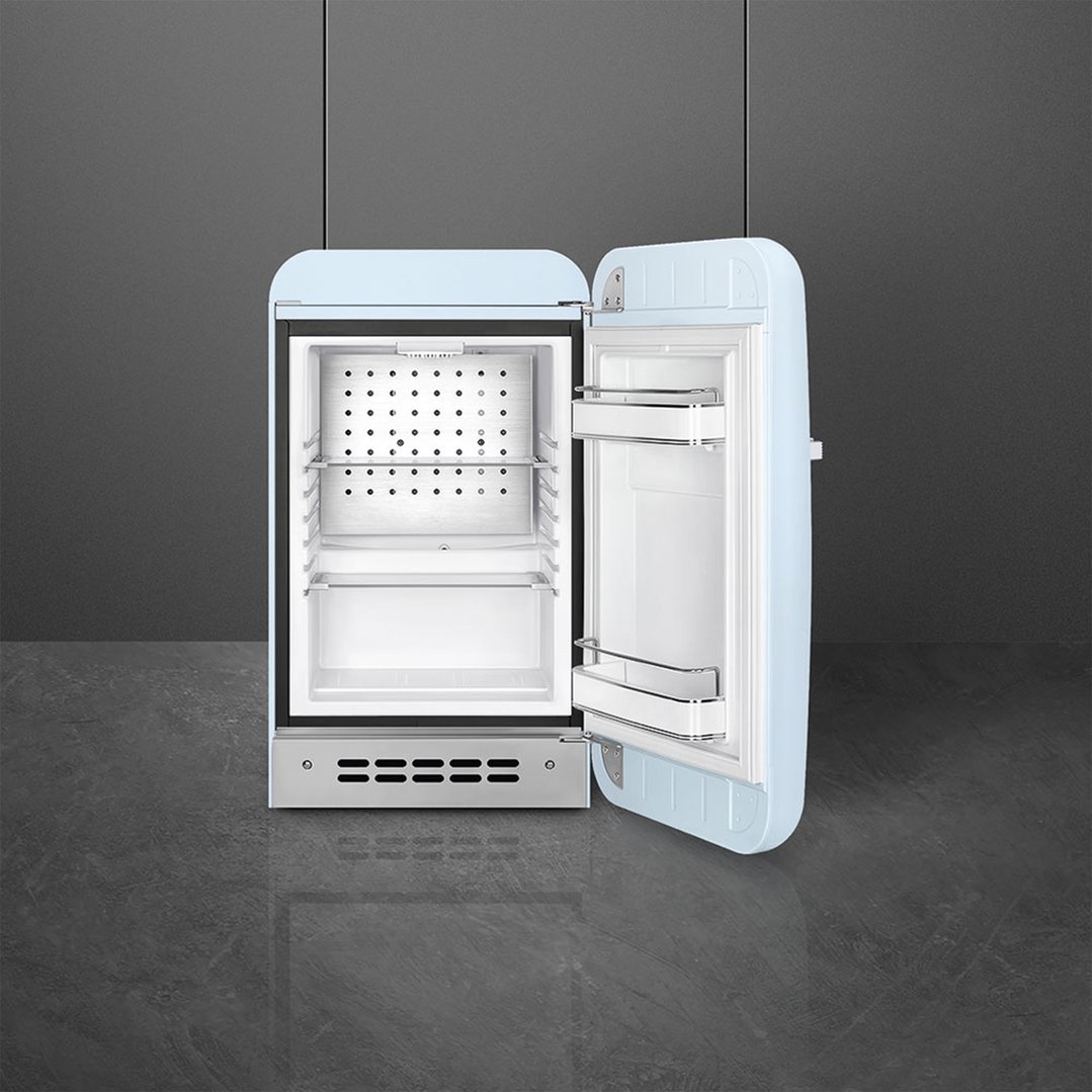 Pastel blue SMEG fridge with door open, showing interior shelves and door storage