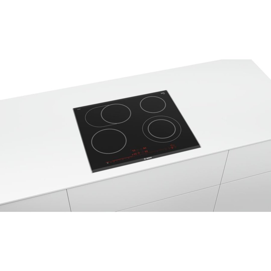 Black ceramic cooktop with four burners on a white countertop