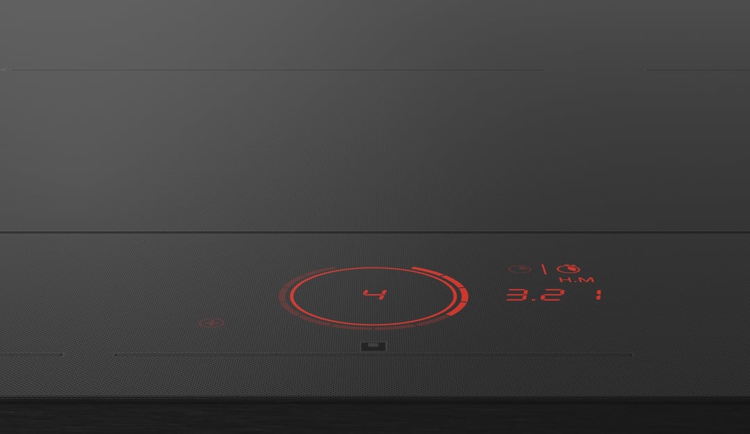 Close-up of an induction cooktop with a red digital display showing settings
