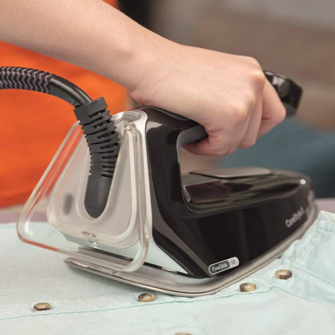 Hand ironing a light blue shirt with a Braun CareStyle 5 Steam Generator Iron
