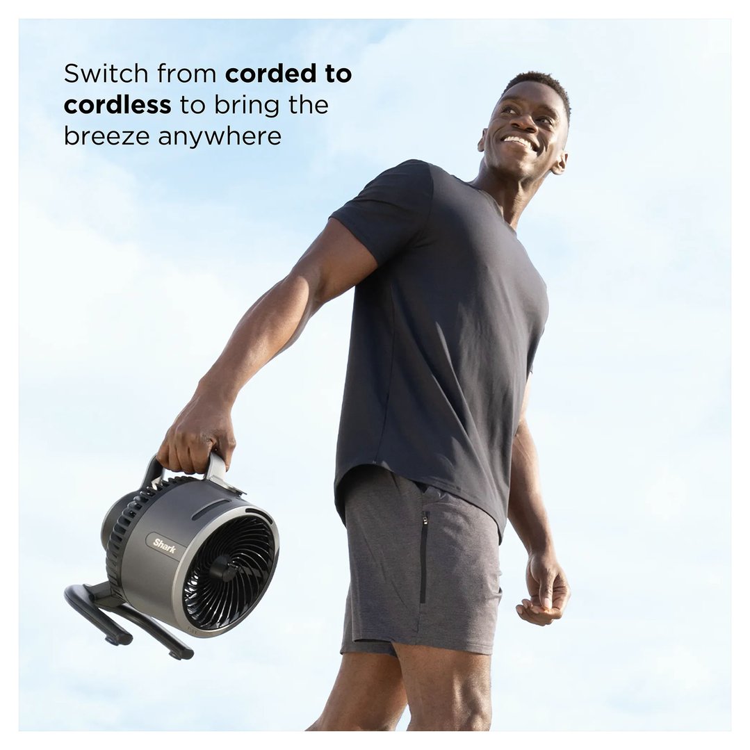 Man holding a Shark FlexBreeze HydroGo Misting Portable Fan outdoors under a blue sky