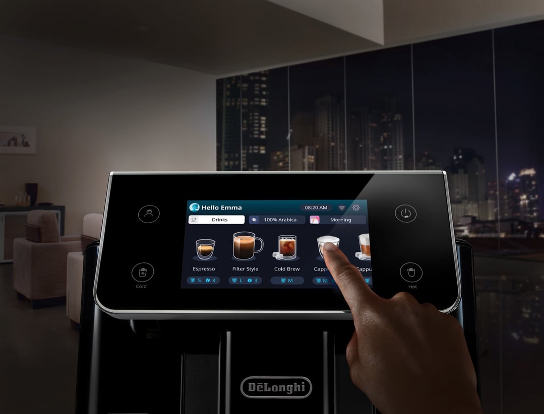 Hand touching the screen of a coffee machine in a modern apartment