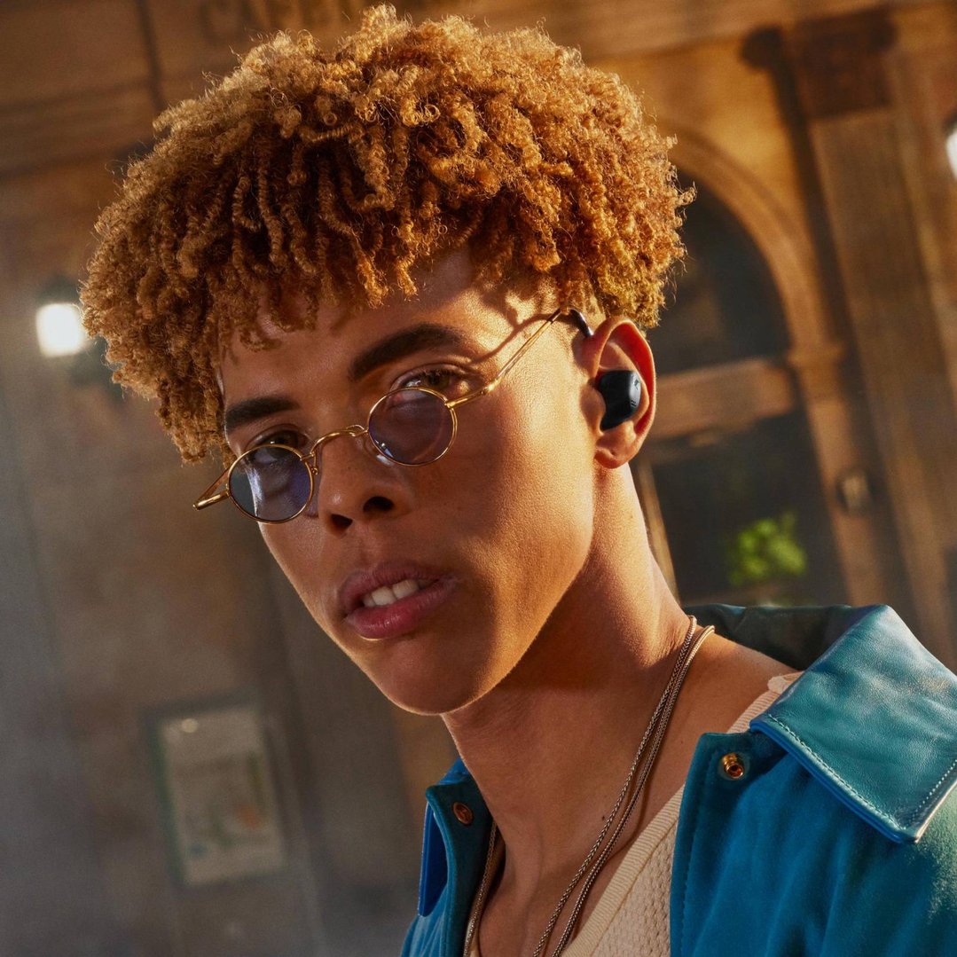 Man wearing SENNHEISER ACCENTUM True Wireless Earbuds in a styled setting