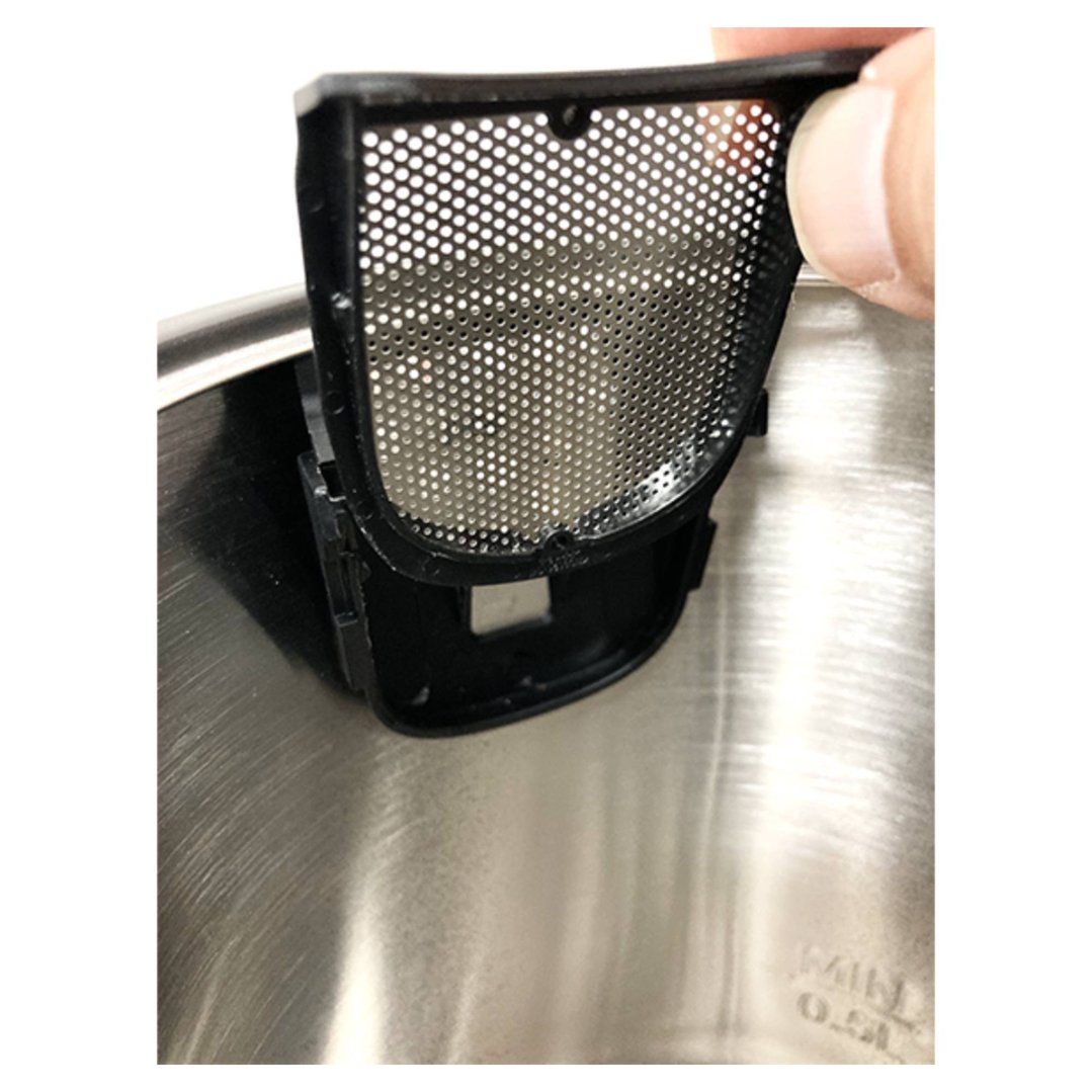 Hand holding the filter of a kettle, showing the inside of the kettle