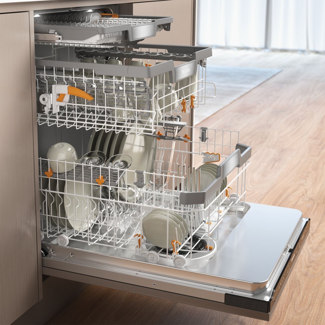 Open Miele dishwasher with dishes inside in a kitchen setting