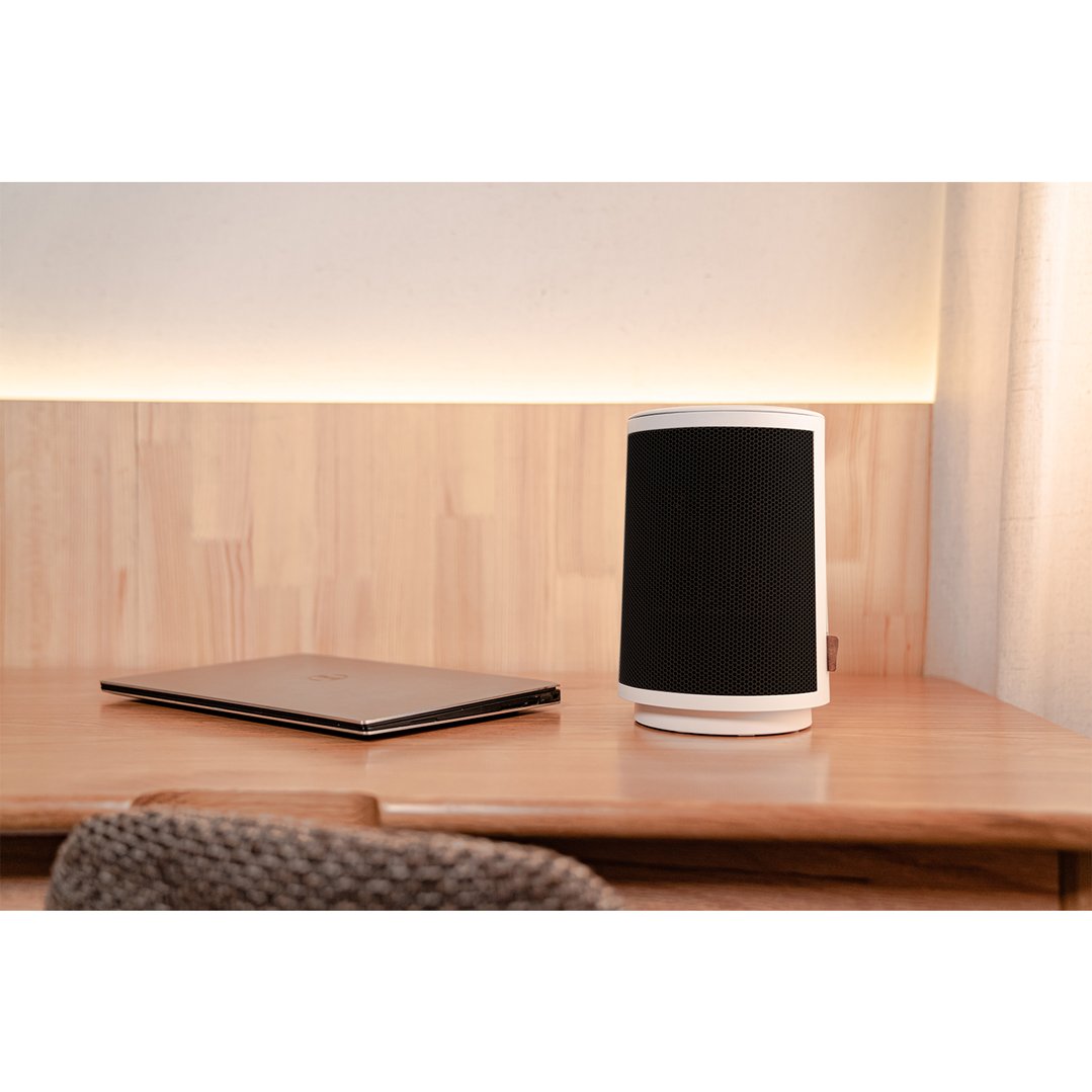 White ceramic heater and a laptop on a wooden desk