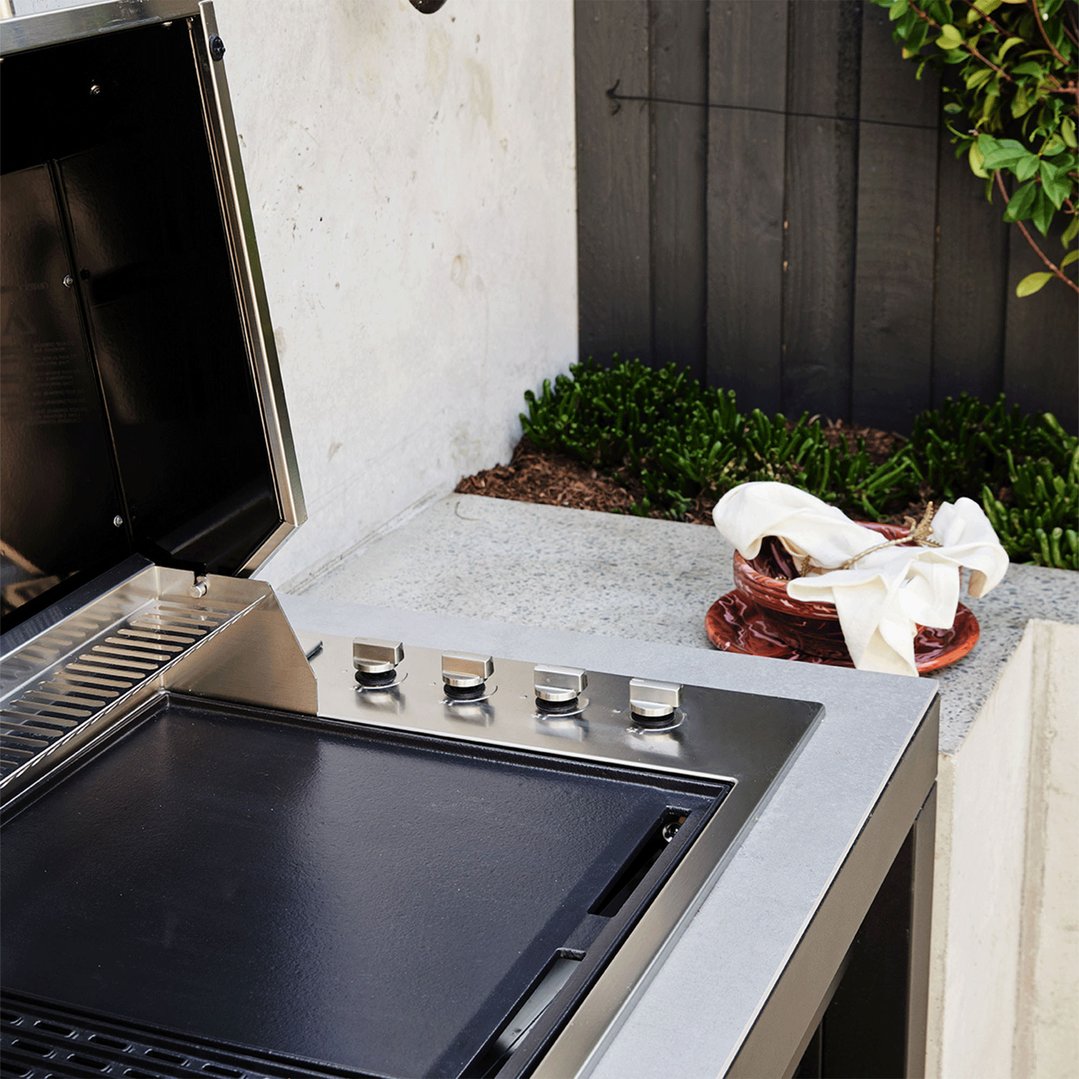 Built-in 4 burner LPG BBQ with lid open in an outdoor setting