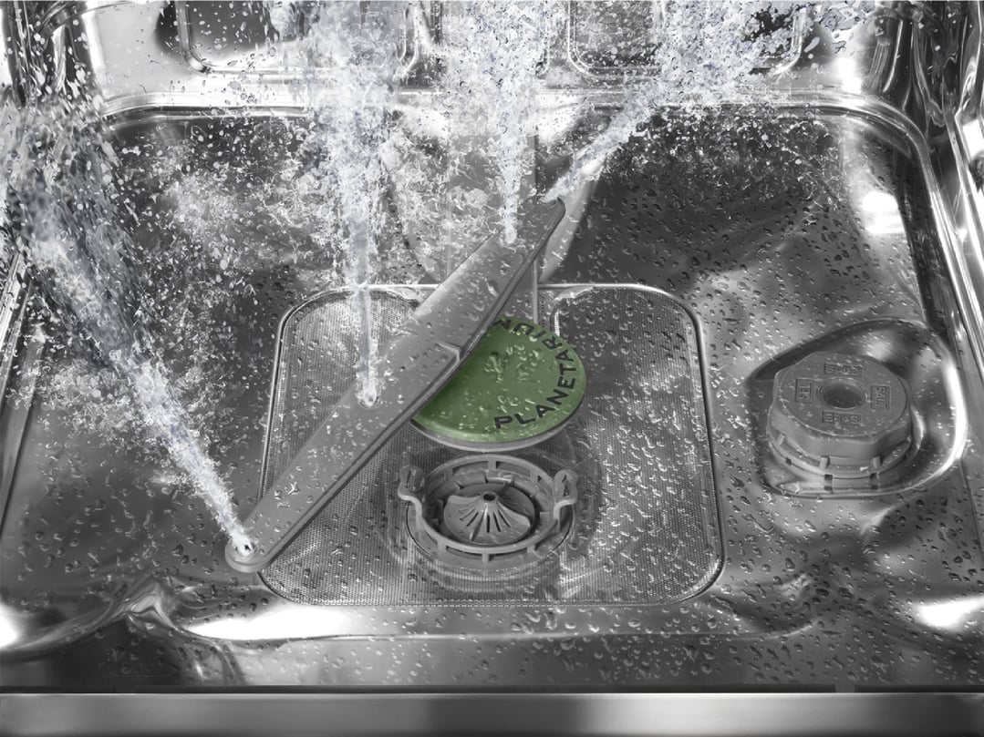 Close-up of the dishwasher interior with water spraying during a wash cycle