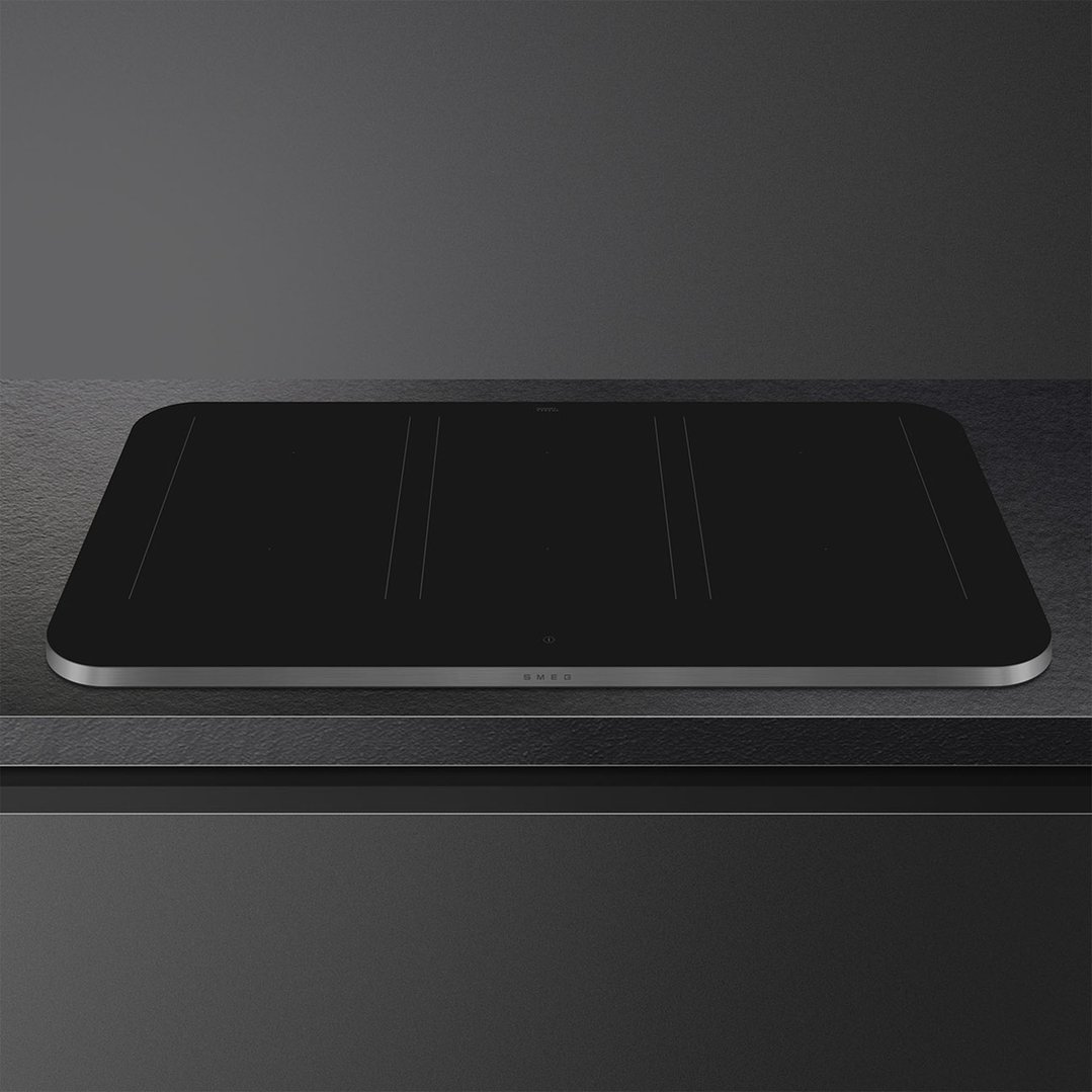 Black induction cooktop with silver trim on a dark countertop