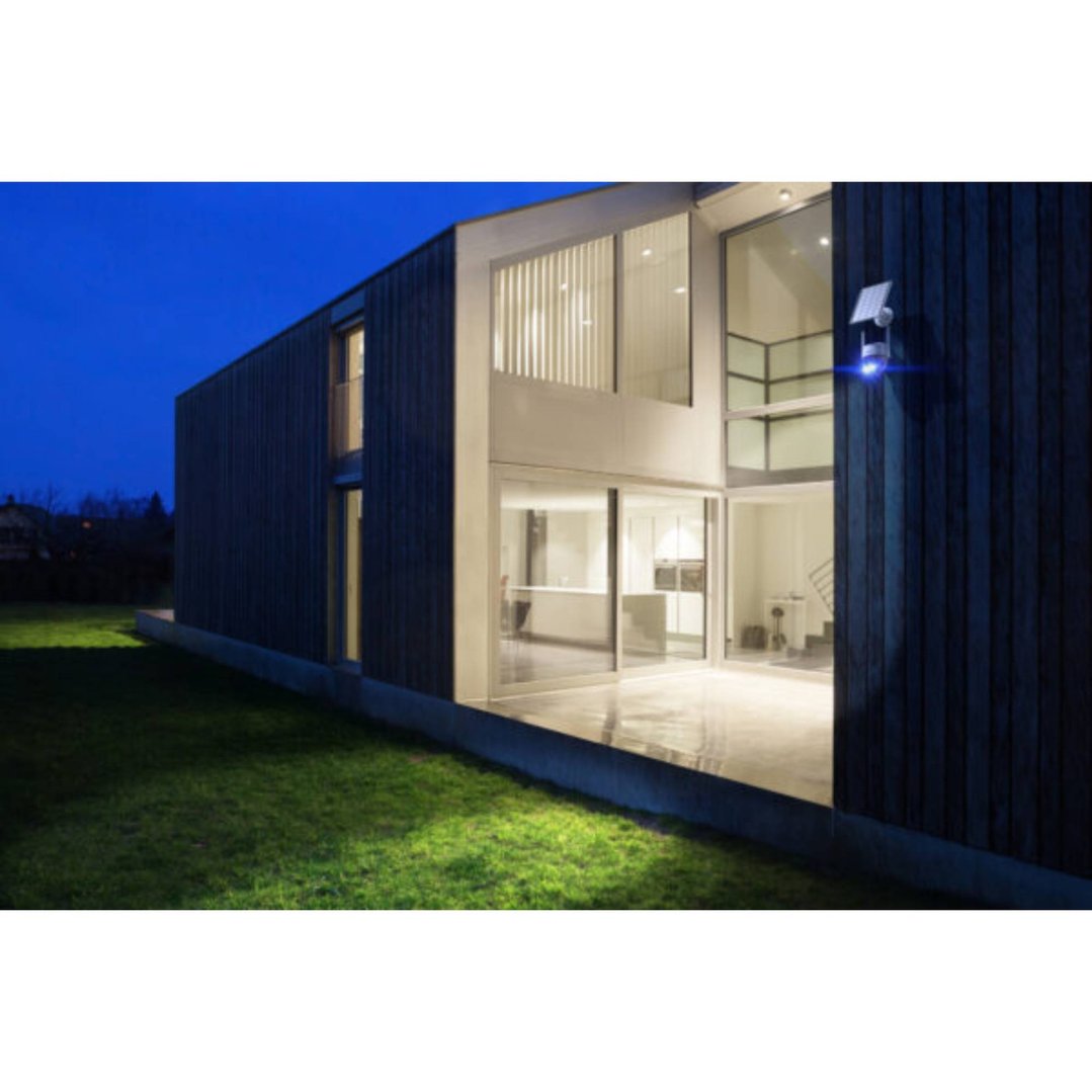 Solar panel for security camera mounted on a modern house at dusk