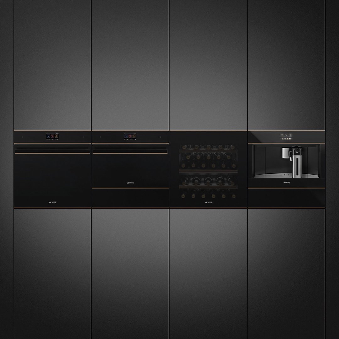 Four built-in ovens, a wine cooler, and a coffee machine in a dark kitchen