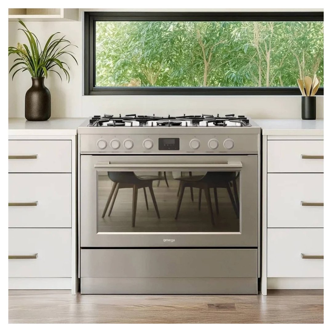 Stainless steel freestanding dual fuel cooker in a modern kitchen with a window view