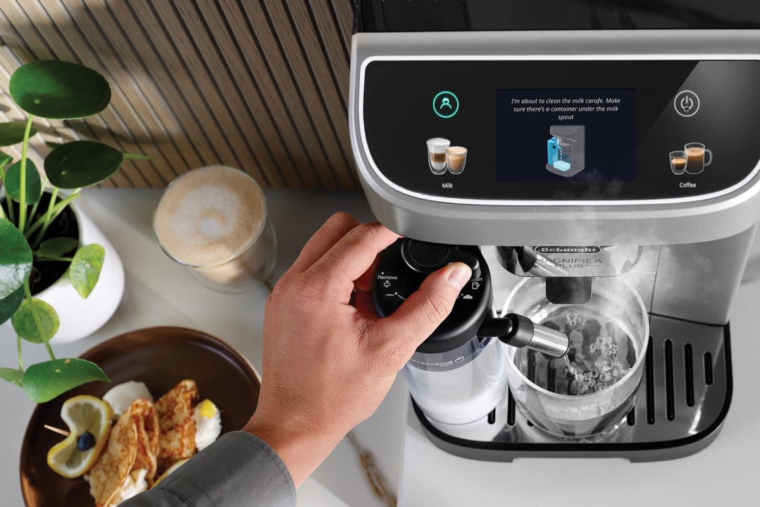 Hand adjusting milk frother on a DELONGHI Magnifica Plus Fully Automatic Coffee Machine