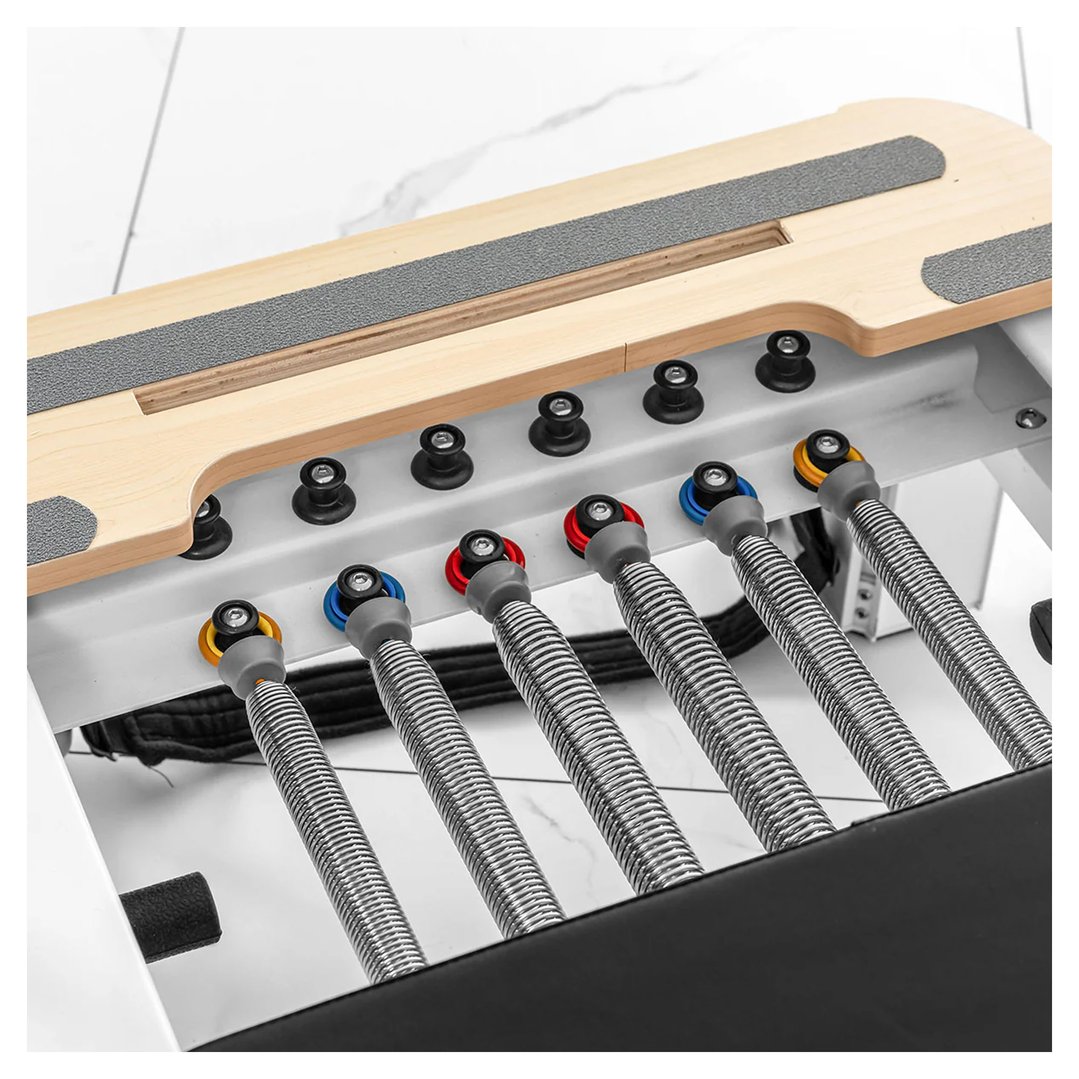 Close up of the springs and wooden platform of a Pilates reformer