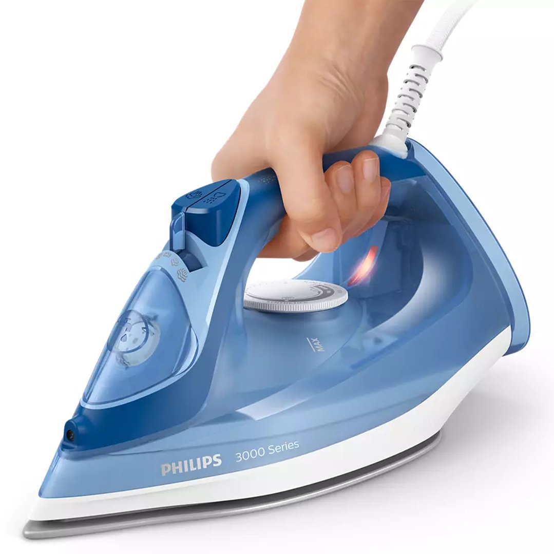 Hand holding a blue Philips 3000 Series steam iron