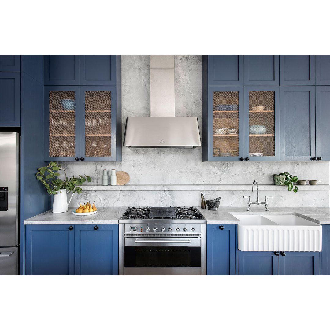 A white double bowl fireclay butler sink in a blue kitchen