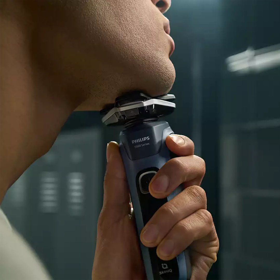 Man shaving his chin with a Philips shaver in a bathroom