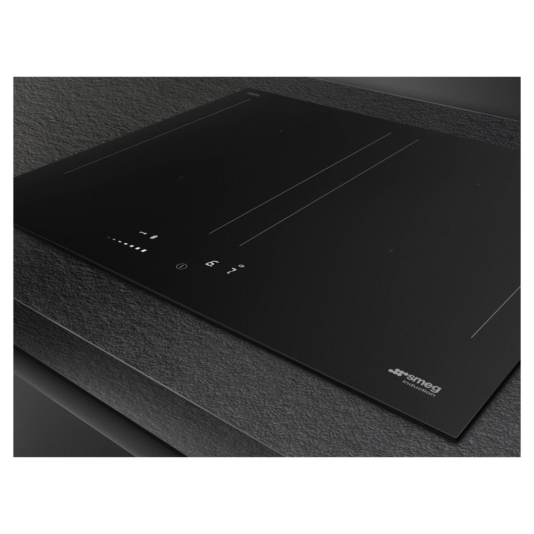 Black induction cooktop with controls on a dark textured countertop