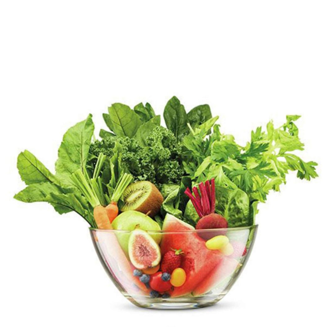 A glass bowl filled with fresh fruits and vegetables on a white background