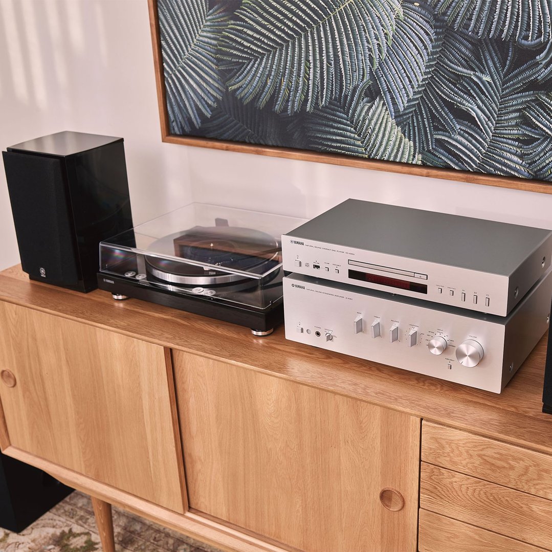 A Yamaha turntable, CD player, and amplifier on a wooden cabinet