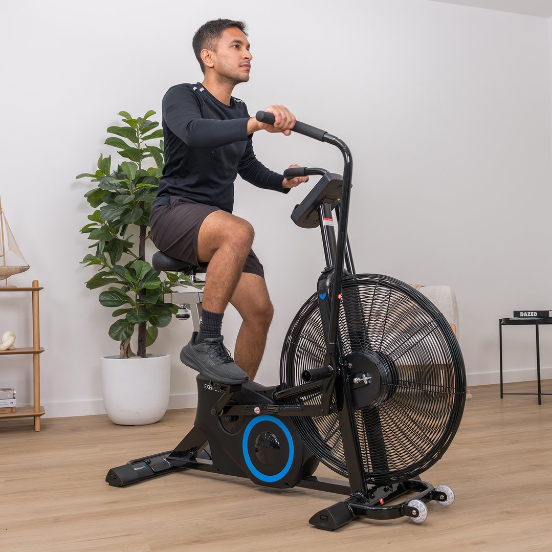 Man exercising on a black exercise bike in a modern room