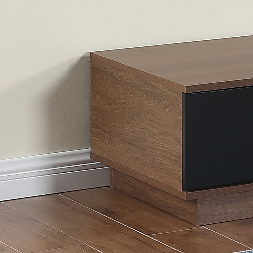 Close up of a dark oak TV cabinet with a black drawer in a room