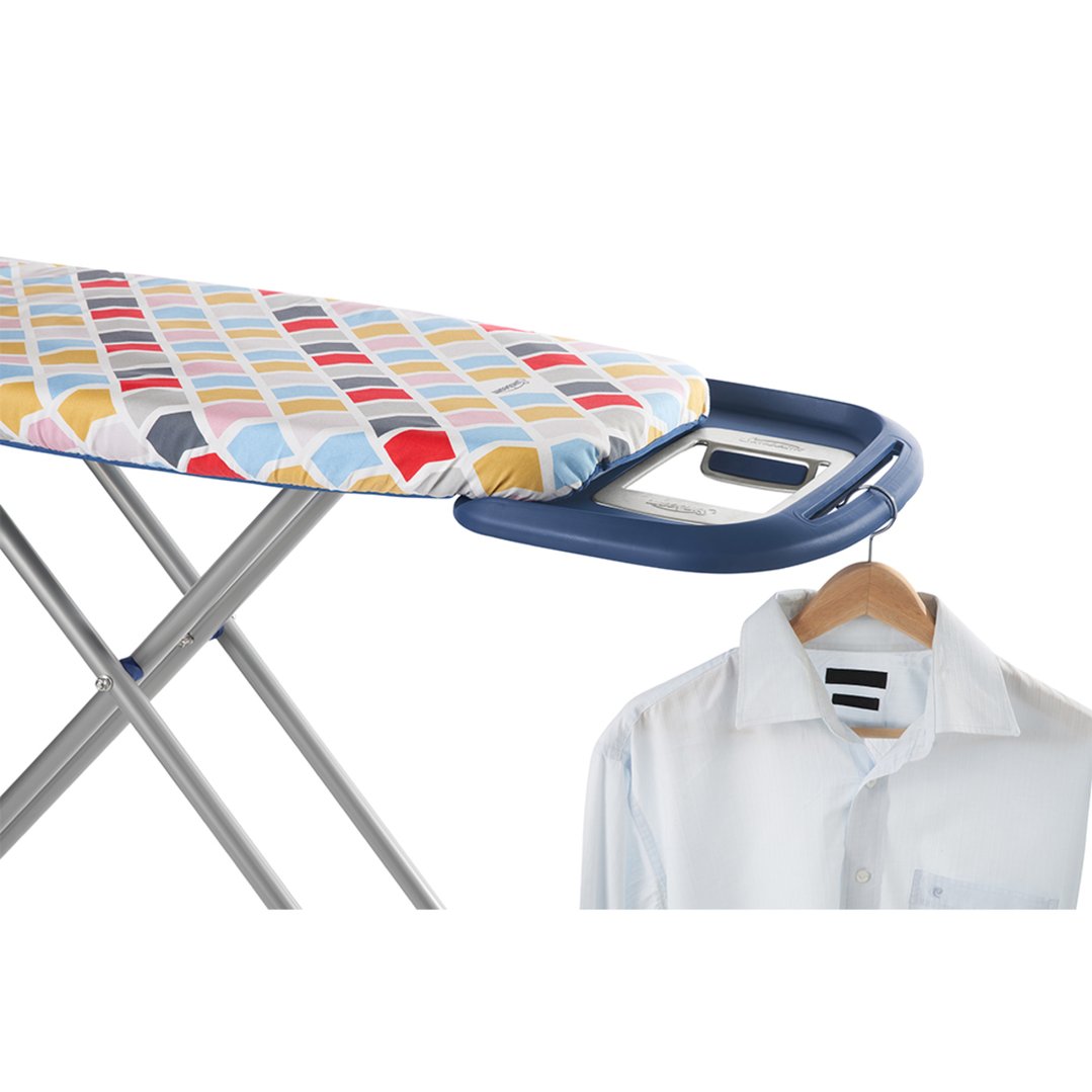Ironing board with colorful cover and a white shirt on a hanger