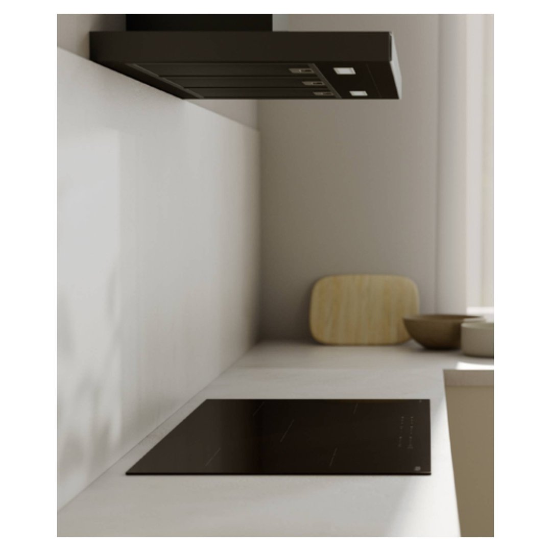 A black induction cooktop installed in a modern kitchen with a range hood