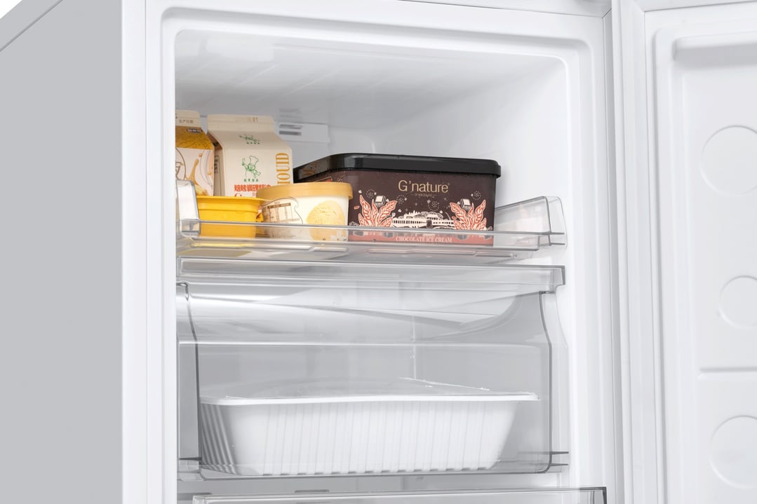 Open freezer showing ice cream, milk cartons, and containers on shelves
