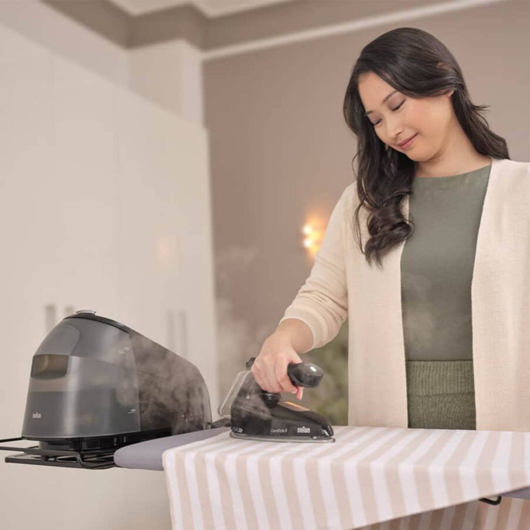 Woman ironing a striped cloth with a Braun CareStyle 5 steam generator iron
